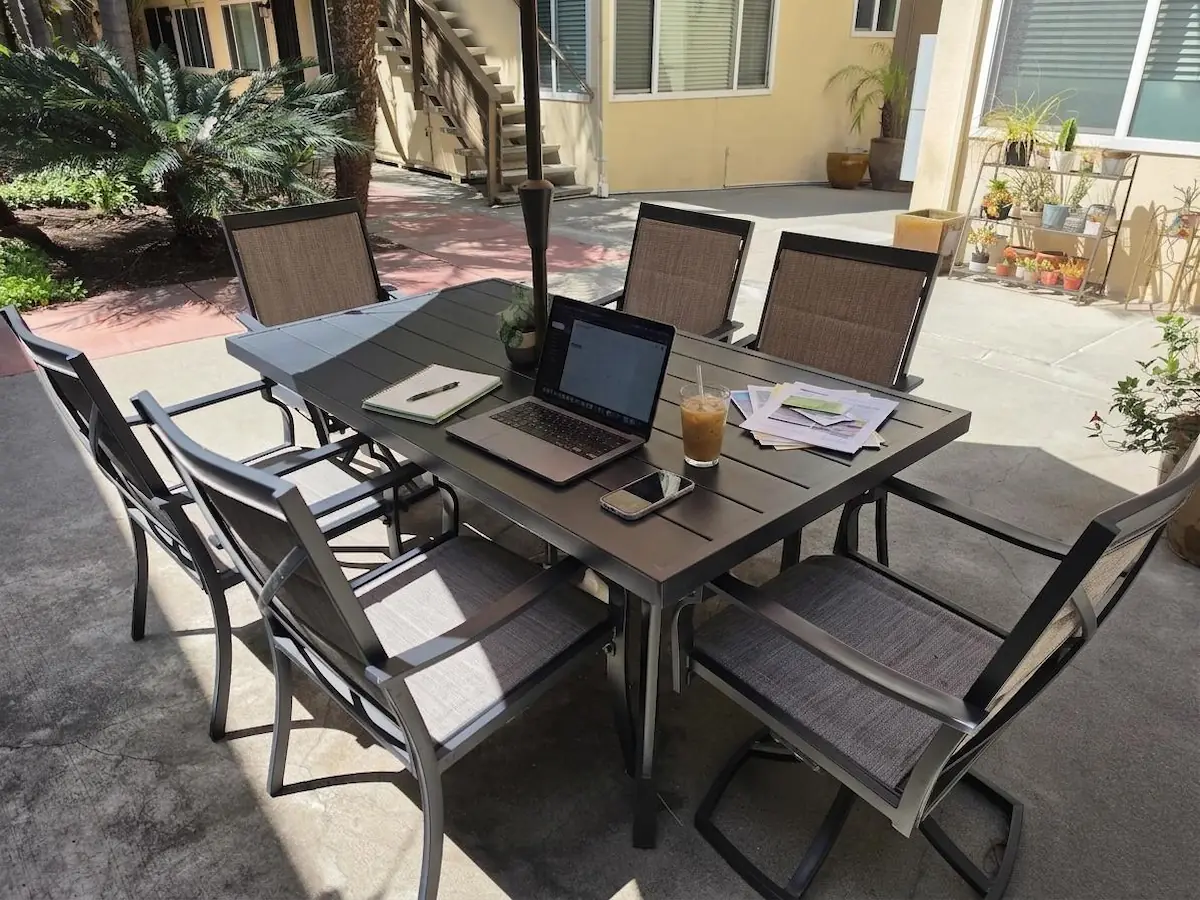 Working from a laptop on the Hillcrest Place courtyard patio&mdash;virtually staged